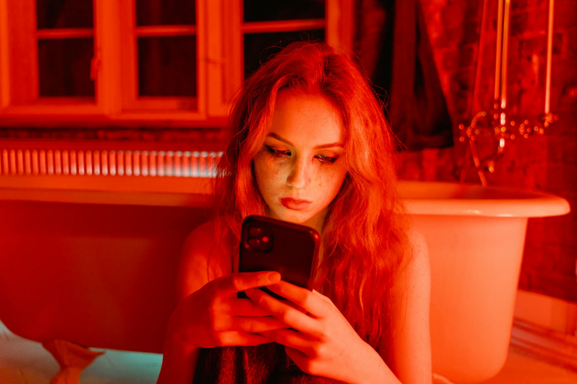 woman with smudge on face holding cellphone